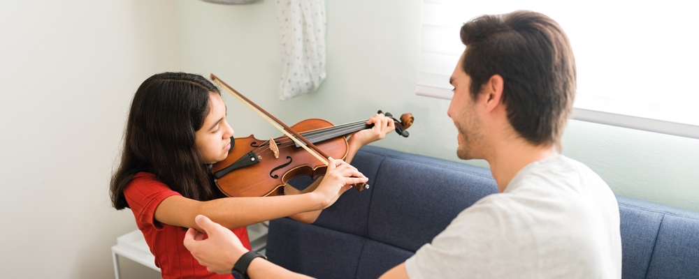 maestro ayudando a su alumna de violin